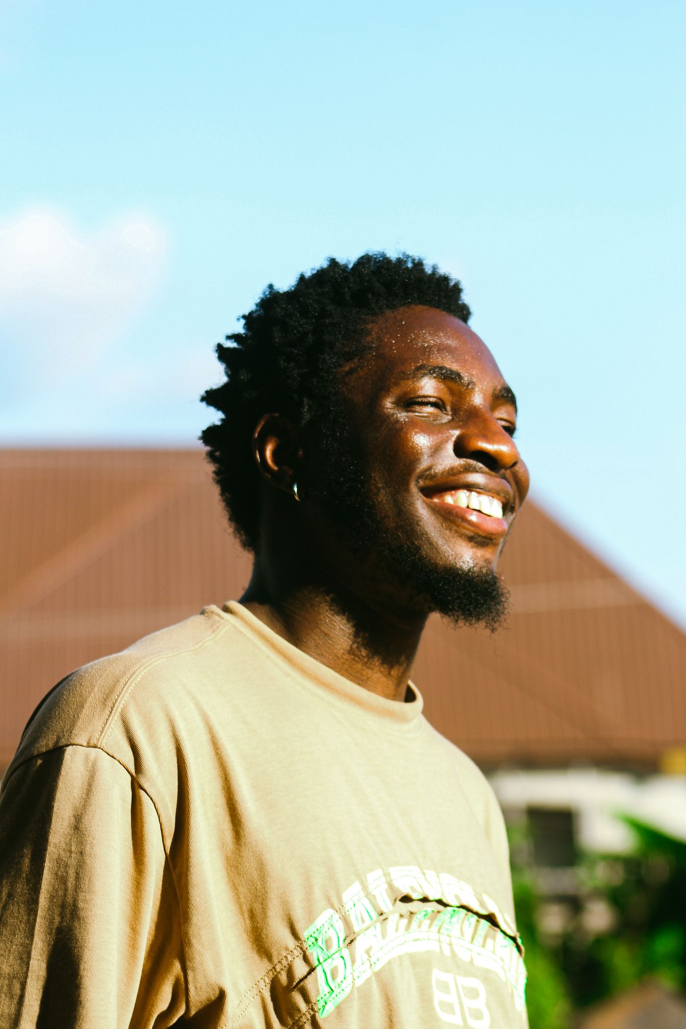 Person smiling outdoors in sunlight